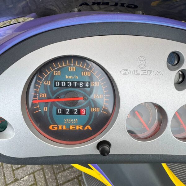 Close up van dashboard van Gilera Runner 180 in blauw en geel, een iconische scooter van Hovingh Scooters