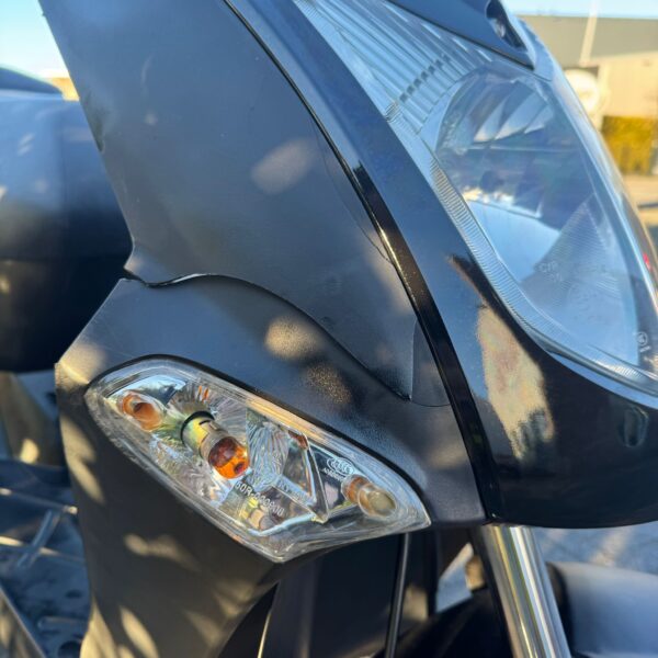 Close up koplamp aanzicht van de Kymco Agility 50 scooter uit 2012, 6122 km, tweedehands te koop voor €599,- met 3 maanden garantie.