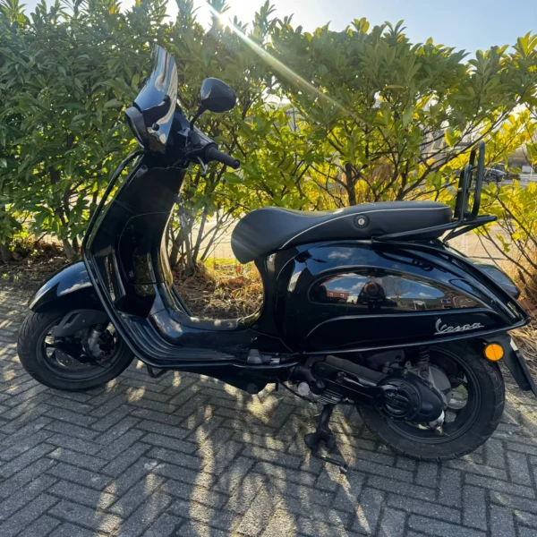 Zijaanzicht van de Vespa Sprint Black on Black uit 2017 met 24.371 km en 3 maanden garantie.