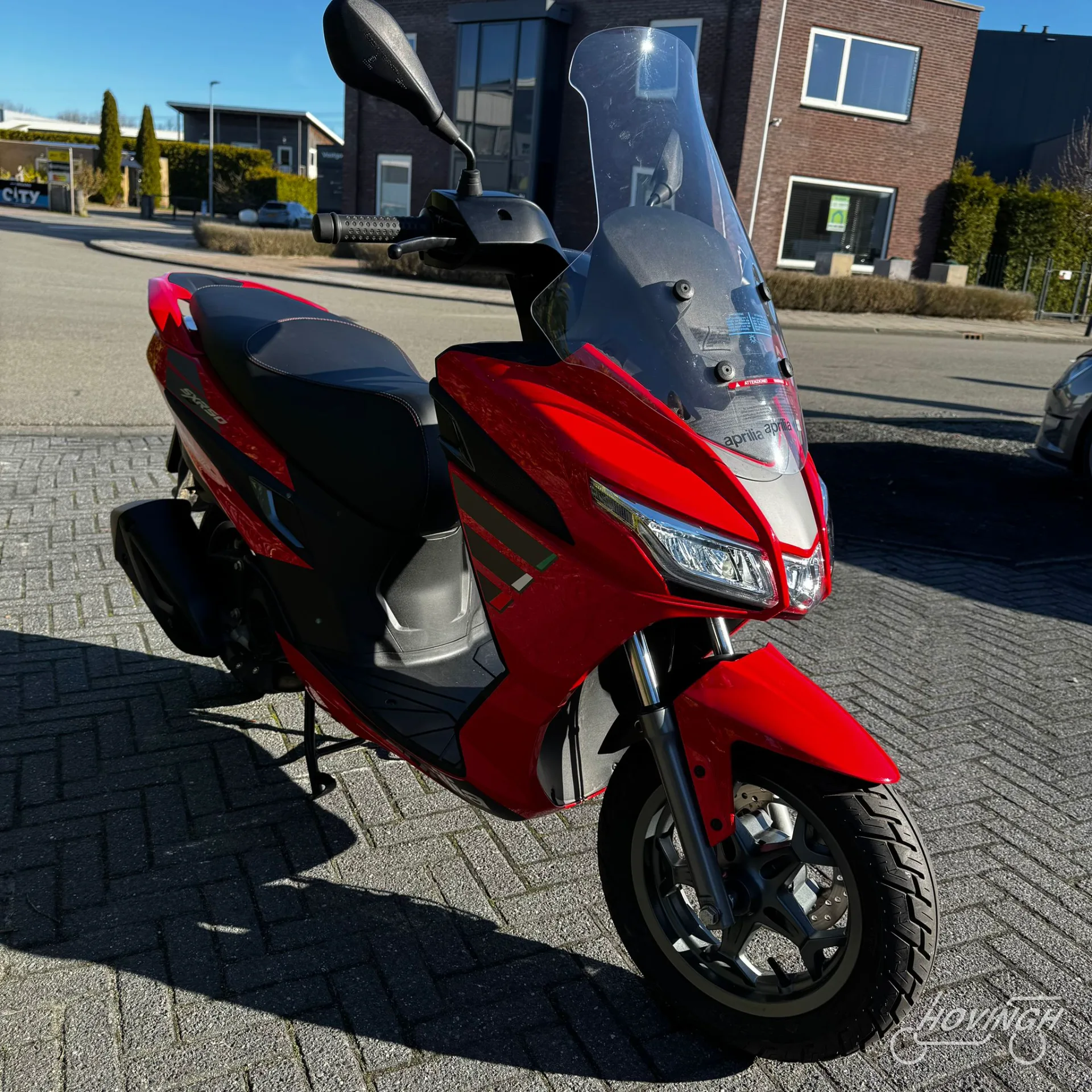 Aprilia SXR 50 2024 rood schuine voorkant rechts geel kenteken