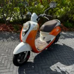 Sym Mio 2009 wit en oranje — voorkant geel kenteken te koop bij Hovingh Scooters Groningen
